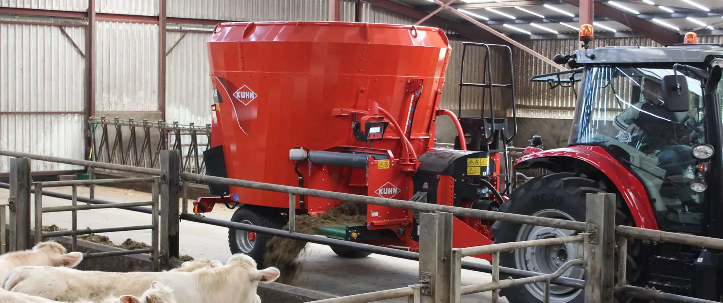 single-auger vertical TMR mixer wagon working in cattle barn